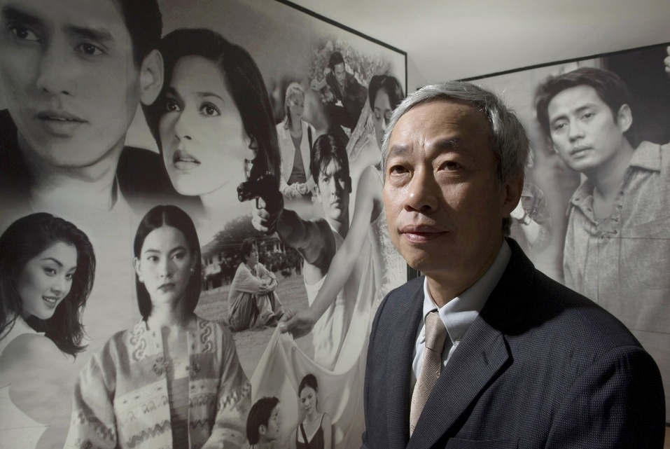 Paiboon Damrongchaitham, Founder and Chairman of one of Thailand's largest music industry companies, Grammy Entertainment poses for a portrait in front of a photo-mural of Grammy actors and actresses who have starred in various films and television dramas and soap operas.